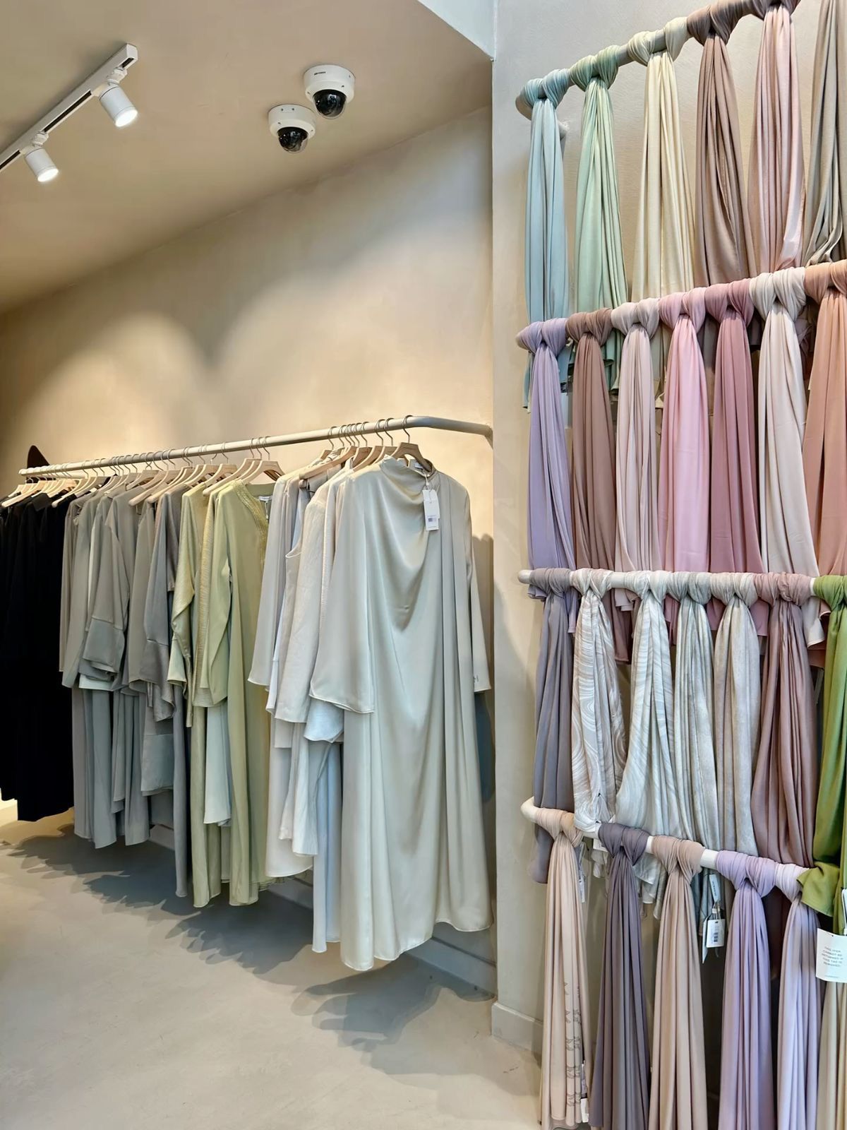 Modern clothing store interior with pastel fabric displays
